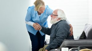 woman helping elderly man sitting